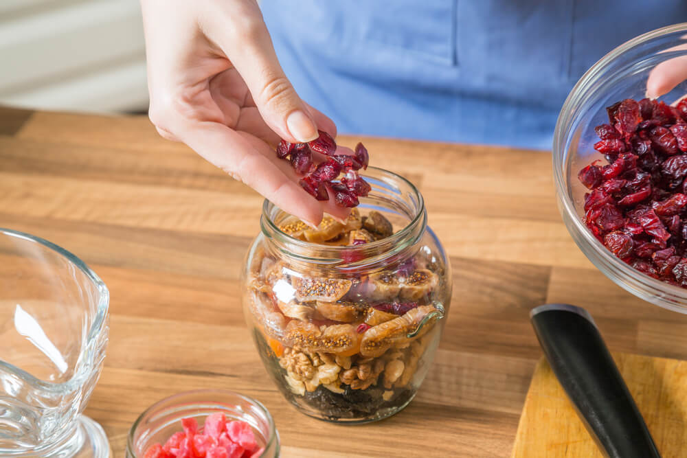 Preparing nut and fruit mix in a jar