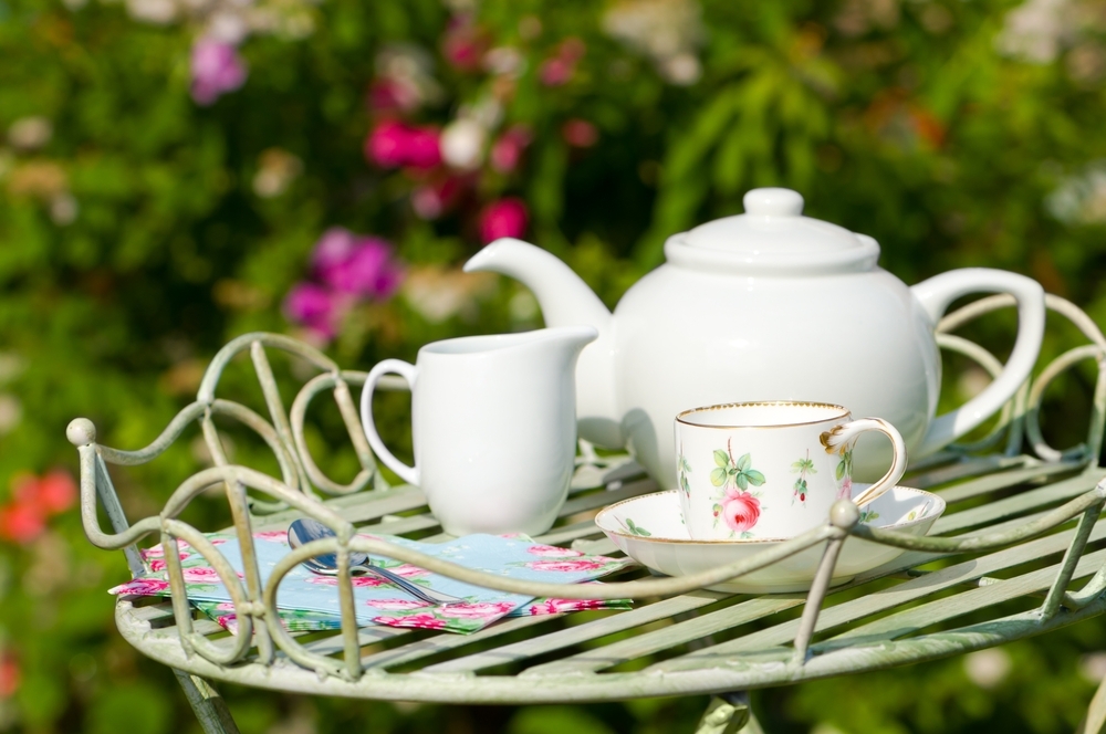 Tea pot and cups outside on a garden table