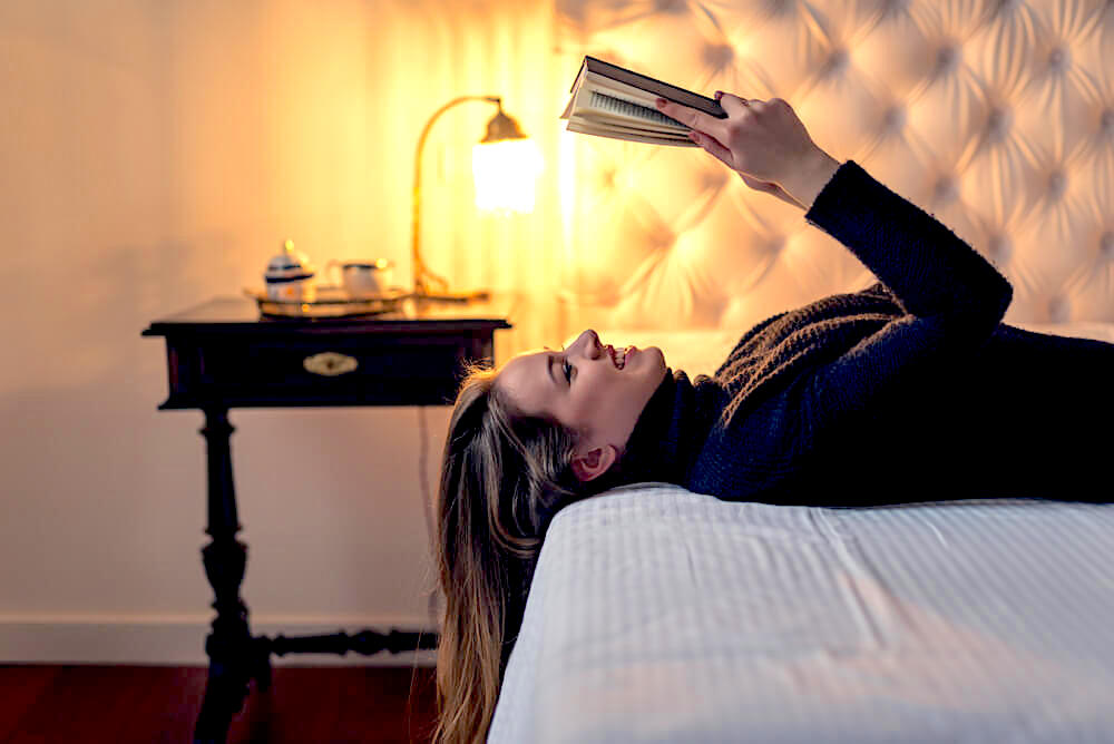 Woman reading happily in bed