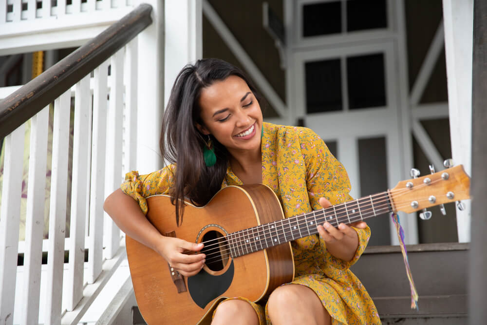 Woman playing guitar on the porch 