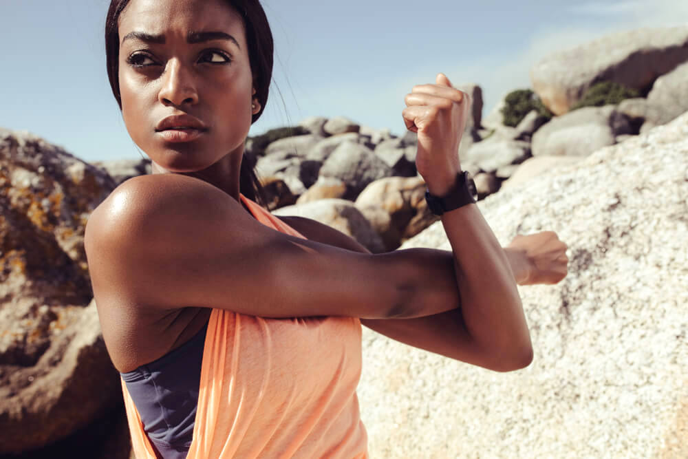 Athletic woman outdoors, stretching her arms