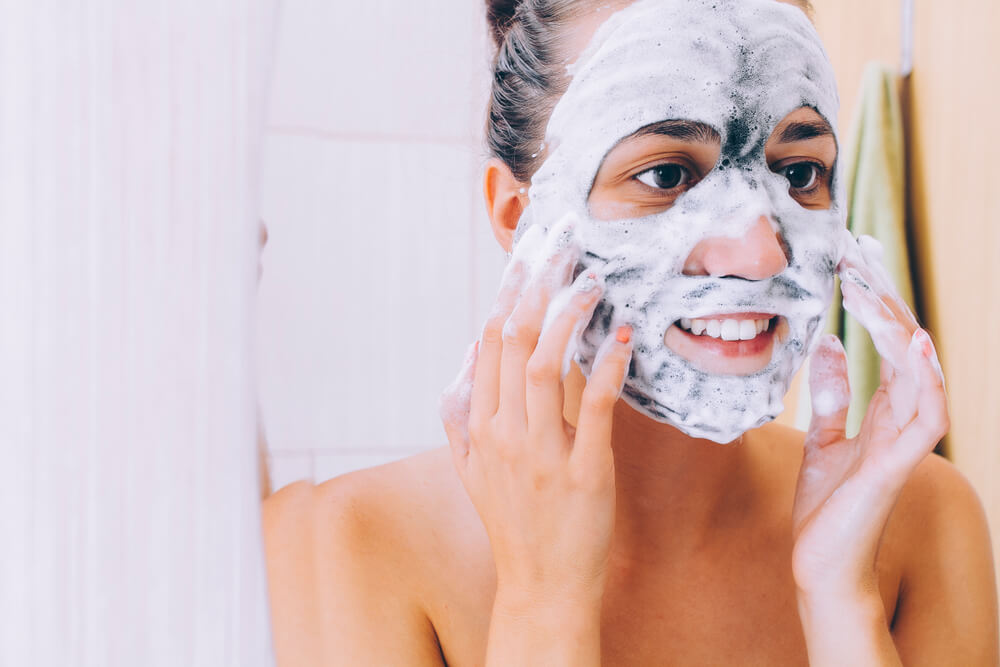 Woman applying foaming face mask