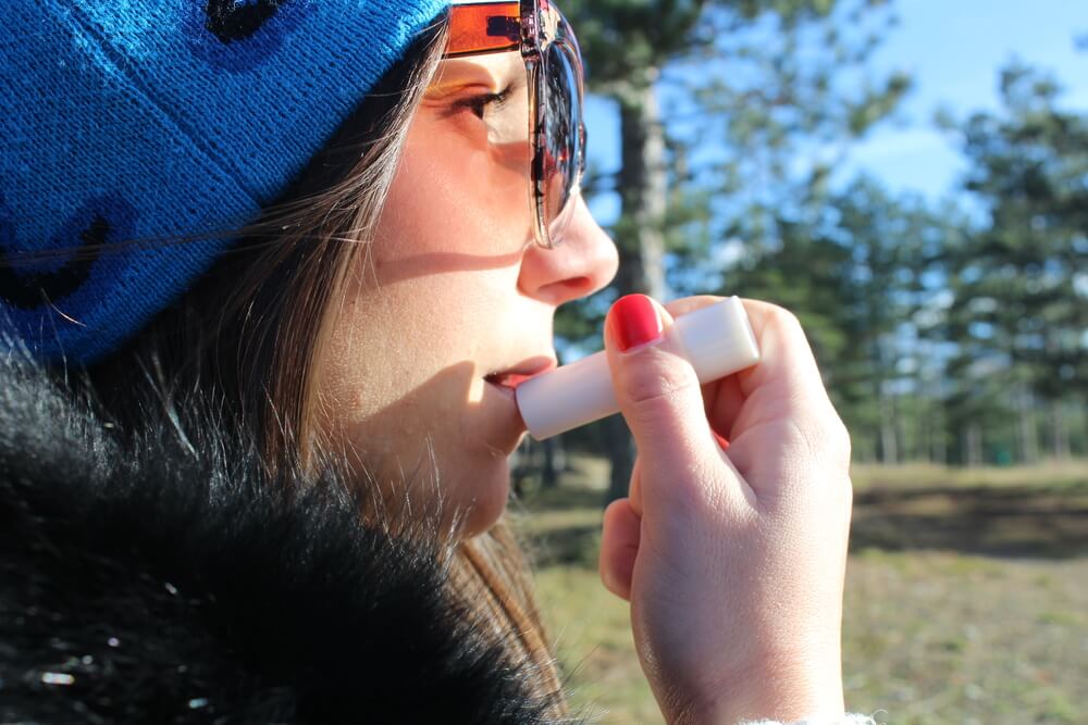 Woman applying lip balm