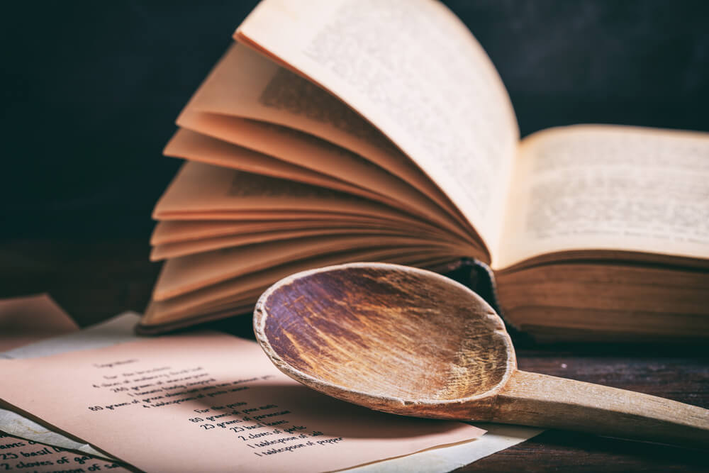 Cookbook on table with wooden spoon