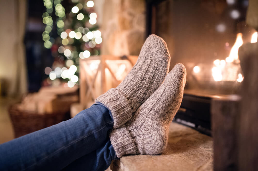 Woman wearing socks with feet up next to candles