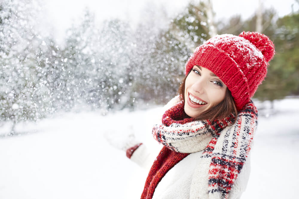 Woman wearing hat and scarf in snow