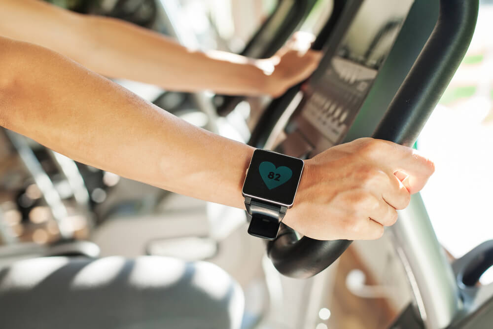 Hands on treadmill with fitness watch