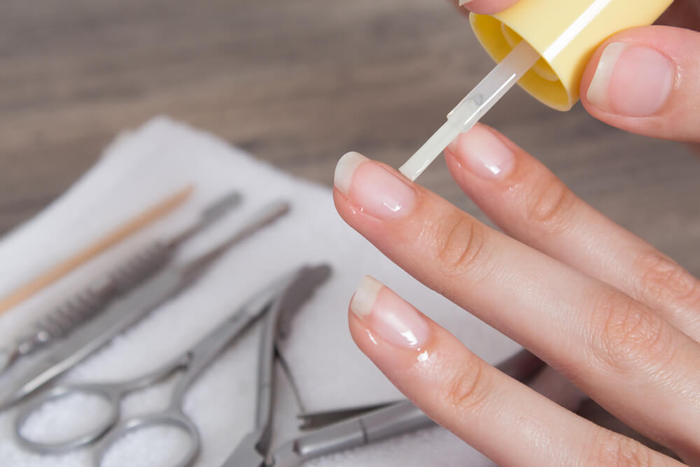 Woman applying nail treatment