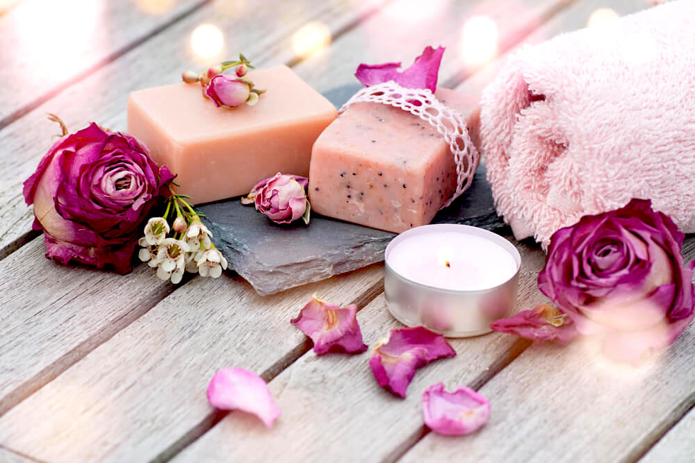 Pink spa soaps and candles on wooden table